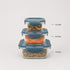 Three stacked transparent glass storage containers with blue lids on a light gray background, shown filled with dried citrus slices, orange lentils, and mixed grains. Small text labels indicate capacities of 14.