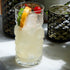 Bartender Tiki glass with a Tiki cocktail with ice and garnishes in a glass on a marble surface