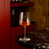 Exclusiva Chardonnay glass with orange wine on a dark marble surface with blurred background
