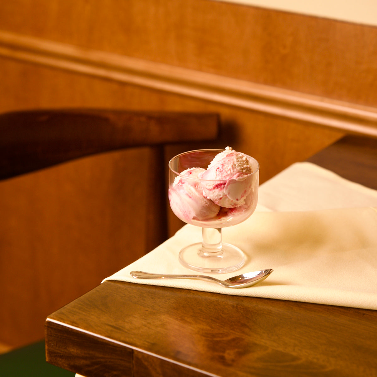 Hosteria dessert glass bowl with pink ice cream on a wooden table