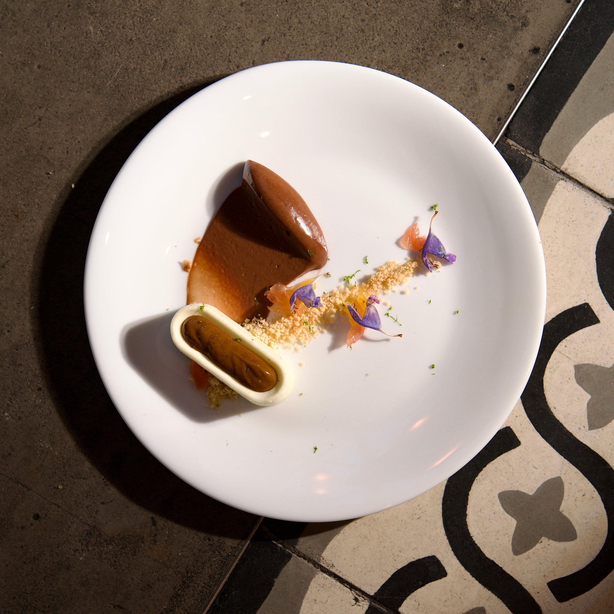Delicate dessert presentation on a white plate with a dark background